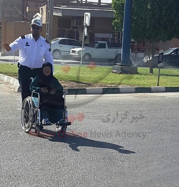تصویر کمک پلیس وظیفه شناس به مادر ویلچری