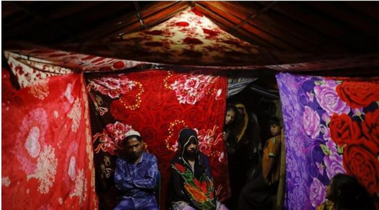 عروس و داماد روهینگیایی در چادری که با پتوهای خوش‌نقش تزئین شده است