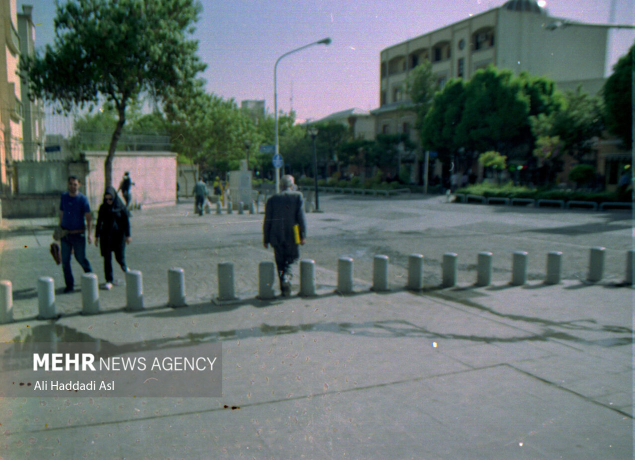 مردی در خیابان ناصر خسرو در حال گذر از خیابان است