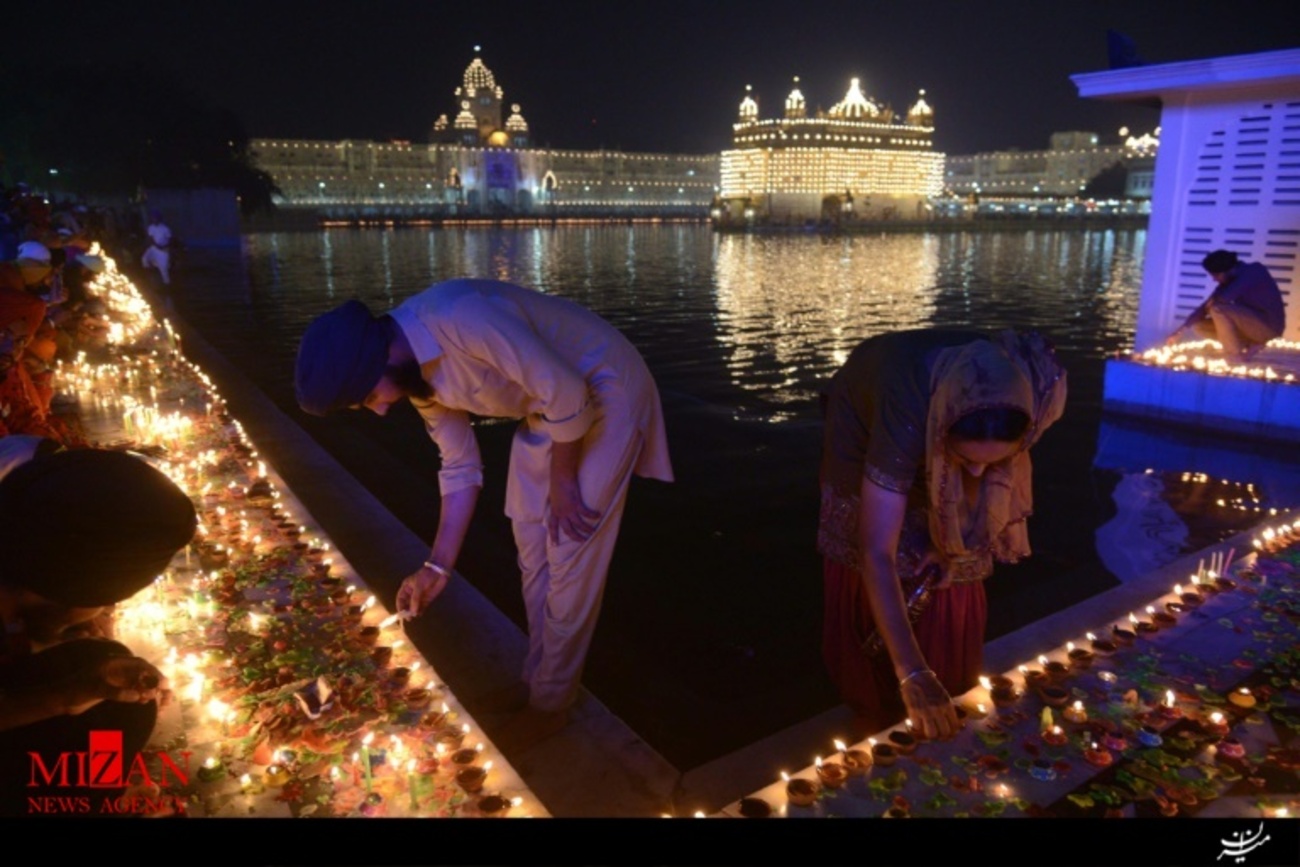 روشن کردن شمع توسط هندوهای مذهب سیک در جشن دیوالی در معبد طلایی آمریتسار