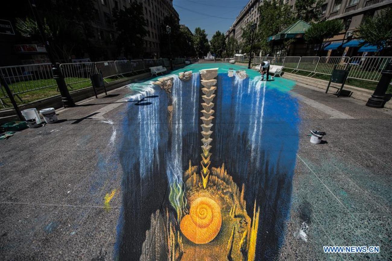 هنرمند آلمانی ادگار مولر در حال کار برروی نقاشی سه بعدی در چهارمین جشنواره با مضمون مسائل شهری در پایتخت شیلی