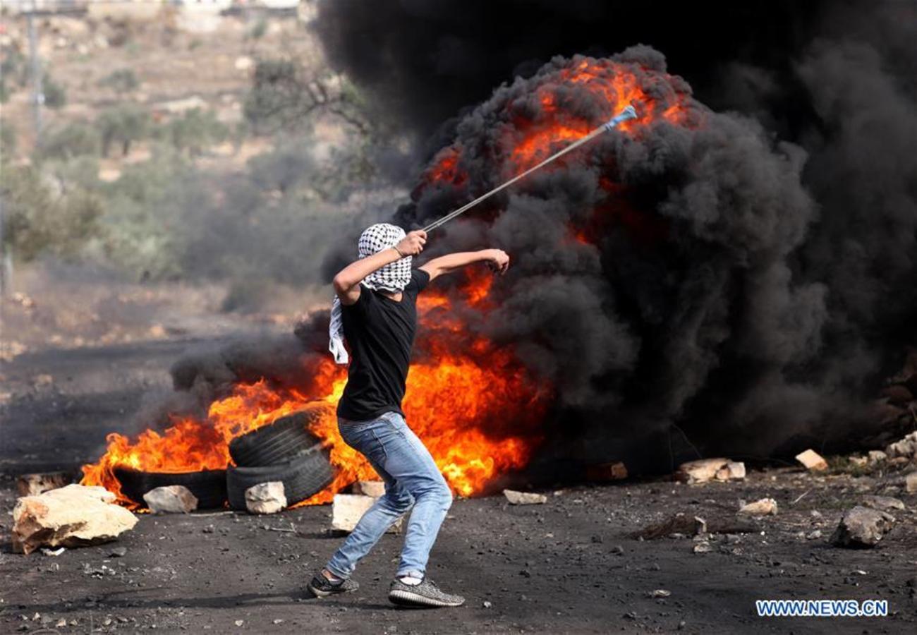 یک معترض فلسطینی در حال پرتاب سنگ به سمت نظامیان رژیم اشغالگر قدس در جریان درگیری ها در غرب نابلس