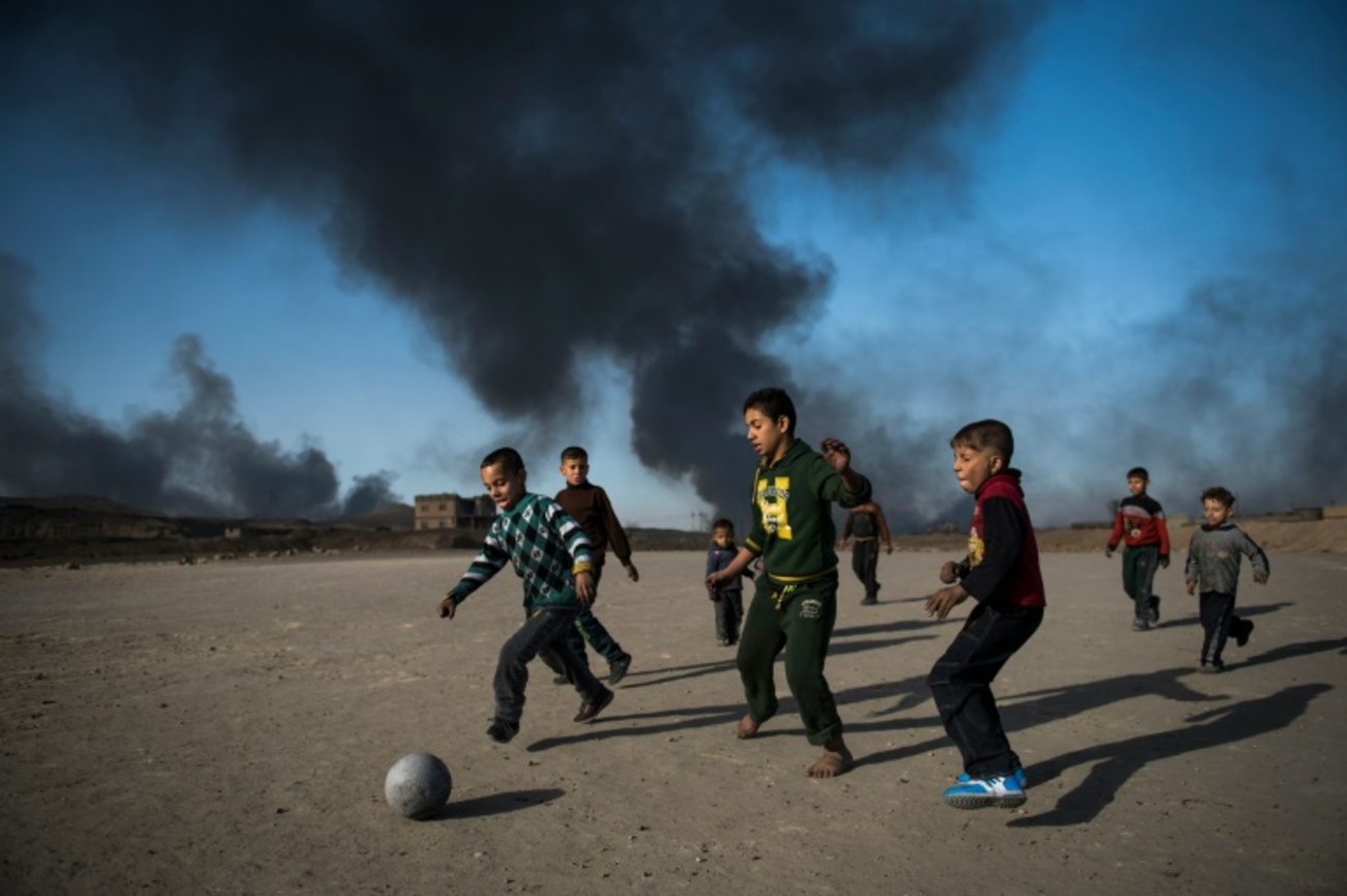 کودکان عراقی در حال بازی فوتبال در کنار چاه های نفت به آتش کشیده شده داعش در بیرون شهر القیاره در 70کیلومتری جنوب موصل