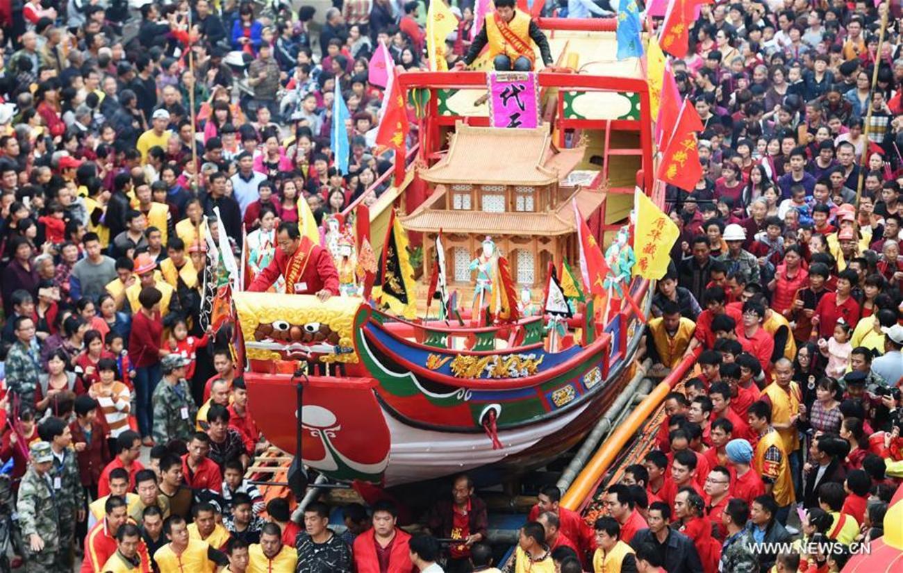 حمل یک قایق نمادین از فرهنگ چینی در طول یک جشنواره محلی در صومعه هوواژنگ در استان فوجیان در جنوب شرقی چین
