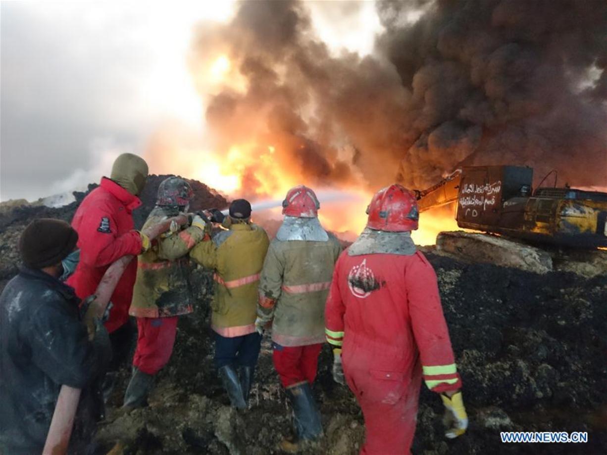 تلاش نیروهای شرکت نفت برای خاموش کردن آتش سوزی چاه های نفت در شهر القیاره در جنوب موصل که توسط داعش به این وضع افتاده اند