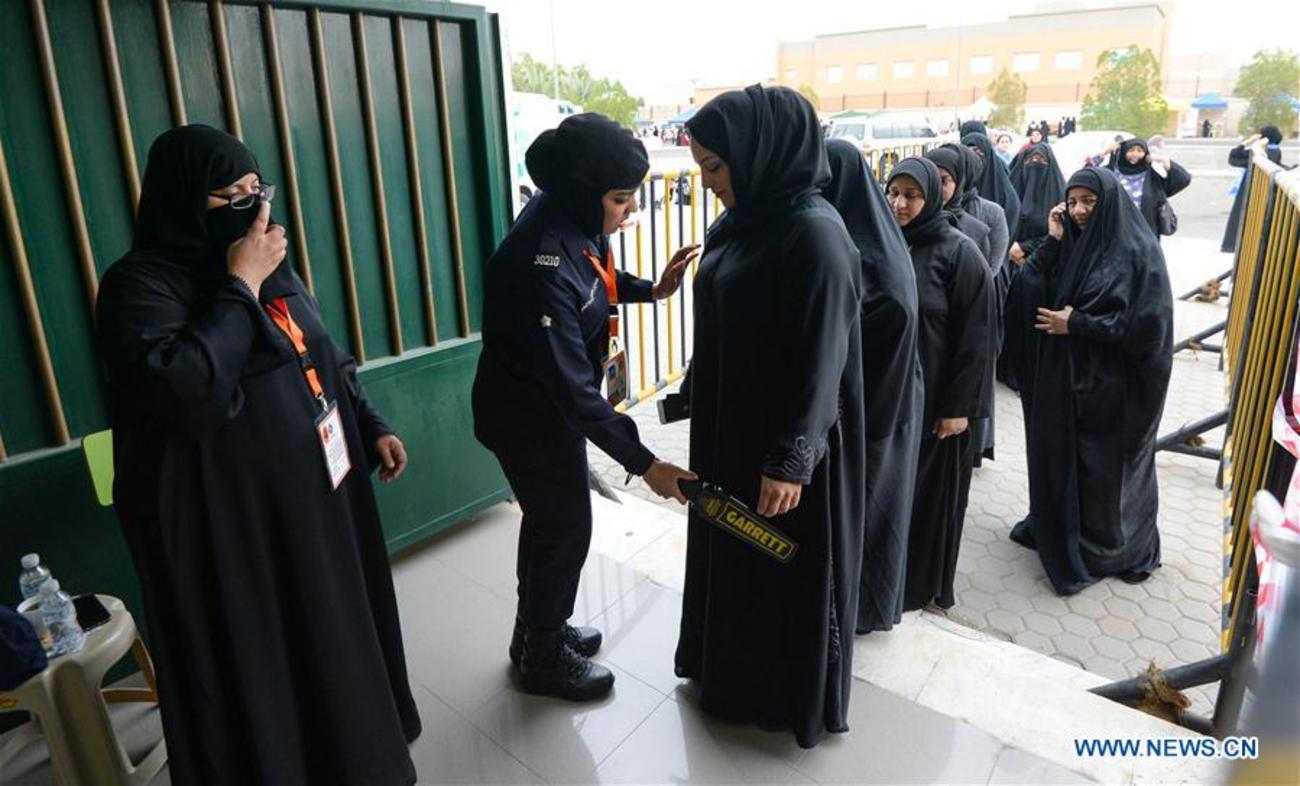 پلیس کویت در حال بازرسی رای دهندگان برای انتخابات مجلس در ورودی یک حوزه رای گیری در پایتخت کویت