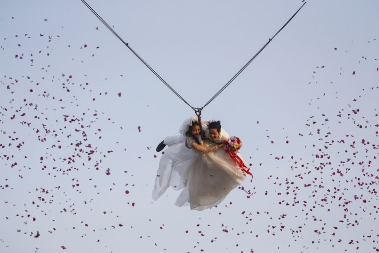 پرواز عروس و داماد  با کابل در طول یک مراسم عروسی در آستانه روز ولنتاین/Athit Perawongmetha/رویترز