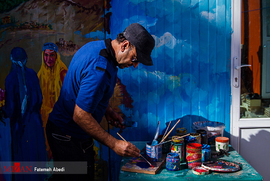 محمد با ذوق و امید، نقاشی را ادامه می دهد.