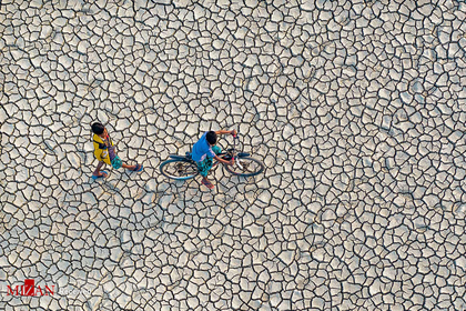 عبور روستائیان از زمین خشک در بنگلادش (زمین‌های دچار خشکسالی شده اند ) ، عکاس : Abdul Momin
