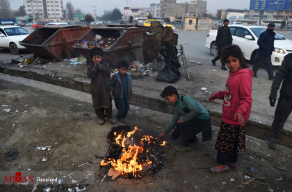 کودکان افغانی برای گرم شدن اشیای پلاستیکی را در کنار خیابانی در کابل آتش می زنند
