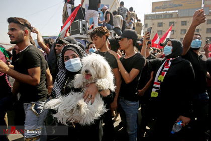دختری با سگش در تظاهرات بغداد، عراق