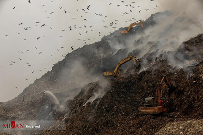 خاموش کردن آتش در یک زباله دانی در هند.