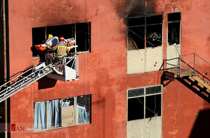 آتش نشانان اسپانیایی در حال خارج کردن اجساد در یک آتش سوزی. 
