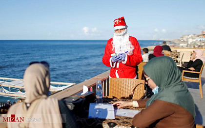 مرد فلسطینی که لباس بابانوئل پوشیده است.