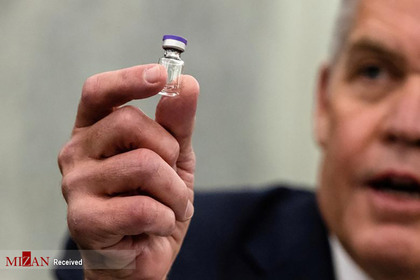 رئیس سازمان بهداشت جهانی در حال نشان دادن واکسن کرونا.