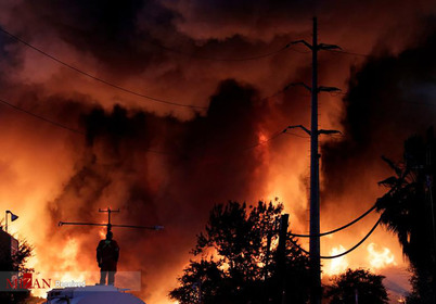 آتش نشانی که روی یک مخزن آب ایستاده است در آتش سوزی مکزیک.
