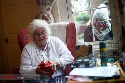 بازکردن کادوهای کریسمس توسط یک مادر بزرگ در لندن.