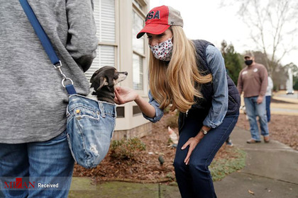 سناتور آمریکایی جمهوری خواه در حال بازی کردن با سگی در صف رای دهندگان.