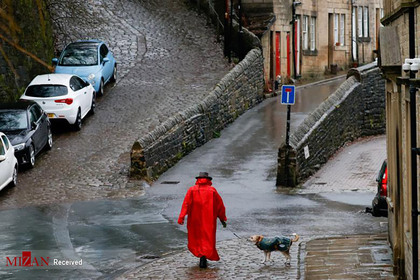 قدم زدن یک زن در خیابان به همراه سگش در شرایطی که احتمال سیلاب با نزدیک شدن طوفان کریستوف به انگلستان وجود دارد.